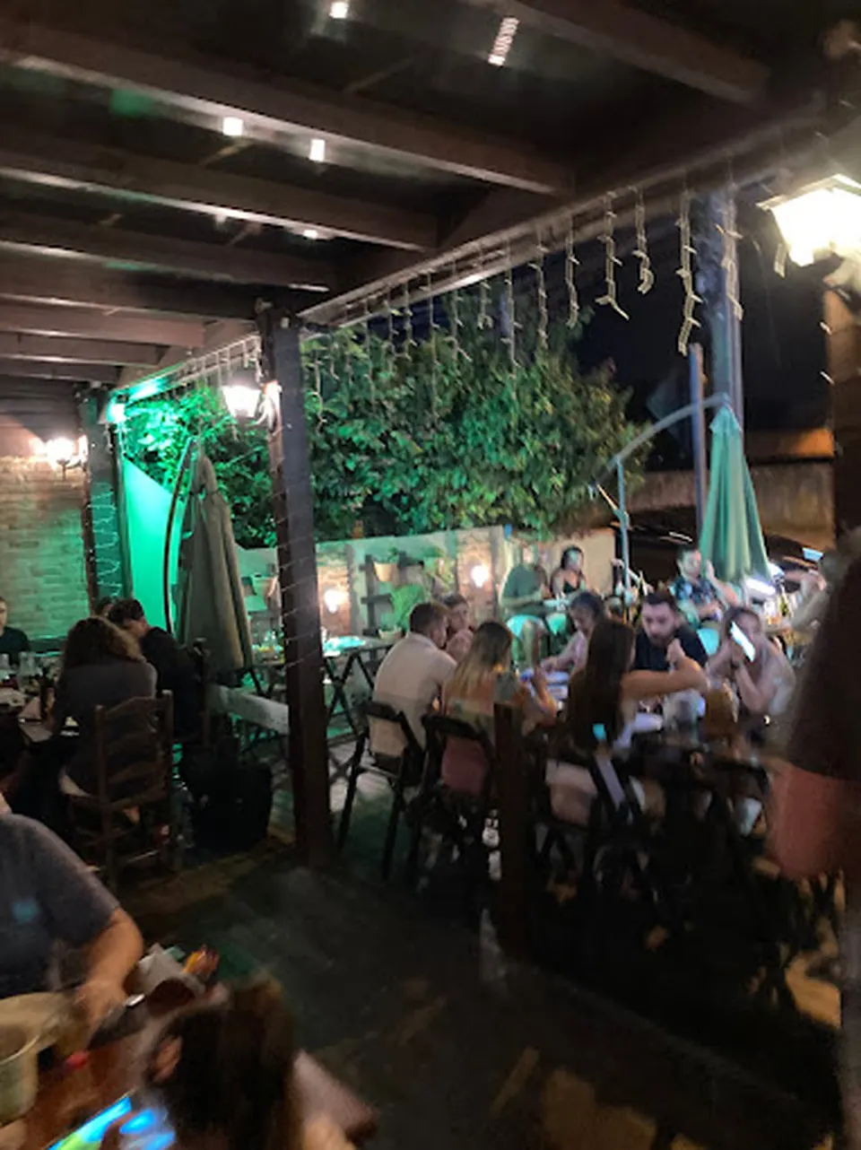 Mesas e área externa da O Forno Pizzaria à noite