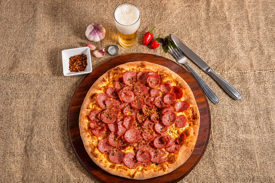 Pizza salgada da O Forno servida à mesa